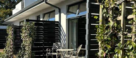 Una casa moderna con un patio amueblado al aire libre y una cerca de madera.