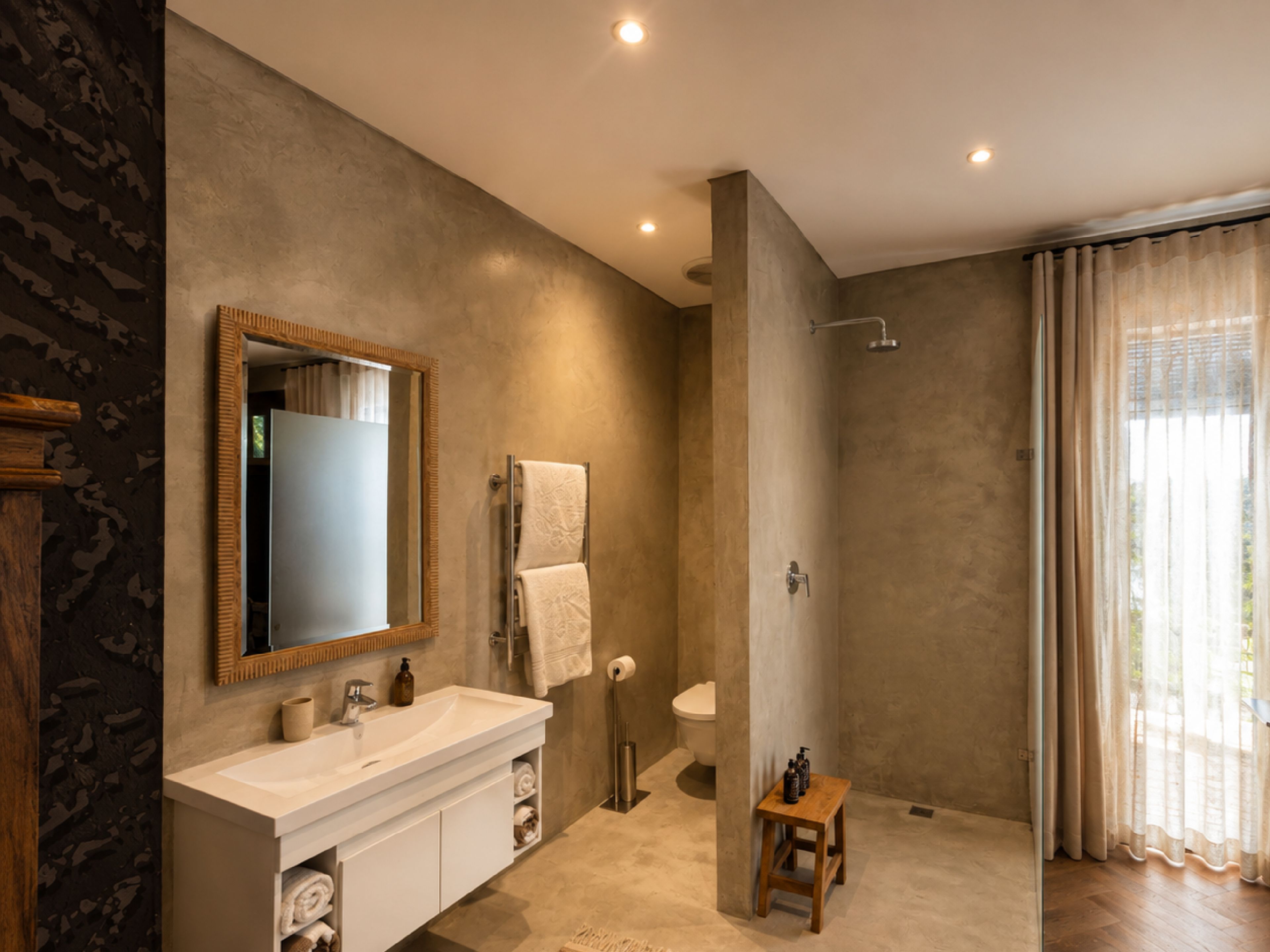 Un baño moderno con un espejo grande, un lavabo, un inodoro y una ducha.