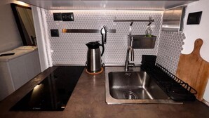 A modern kitchen with a stainless steel sink, a coffee maker, and a built-in stove. - Modern One-Bedroom Apartment in Kypseli - 1000 Mbps Fiber Wi-Fi (Athina)