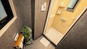 A compact bathroom with a shower, a toilet, a bench, and a potted plant. - A 5-minute walk from Yoyogi Station on the JR Yamanote Line; an apartment for 3 people (渋谷区)