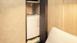 A compact room with a bed, a built-in washing machine, and a wooden wardrobe. - A 5-minute walk from Yoyogi Station on the JR Yamanote Line; an apartment for 3 people (渋谷区)