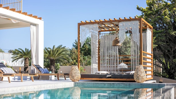 A poolside area with a wooden pergola, lounge chairs, and a decorative canopy. - Kallisti Luxury Villa (Rhodes)