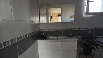 Een douche, een haardroger, handdoeken, toiletpapier