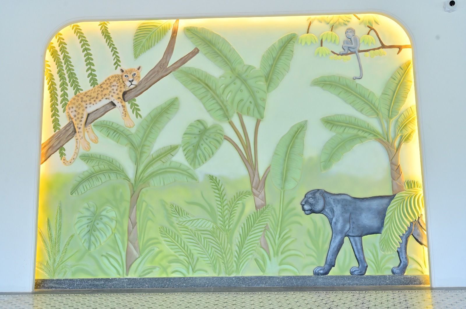 Eine Wandmalerei mit Dschungelmotiv, zeigt einen Leoparden und einen Panther.