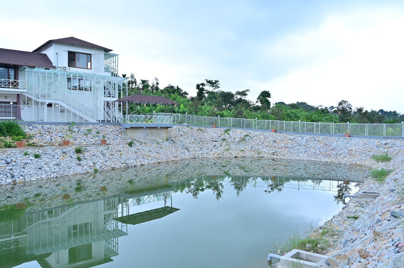 Un barrio residencial con una casa, una piscina y un terraplén rocoso.