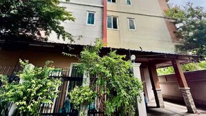 A multi-story building with a flat roof, a red vertical feature, and a gated entrance. - 208 Budget Room Wi-Fi &Utilities Bangkok’s center (Bangkok)