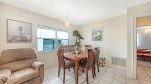 A dining area with a table, chairs, a plant, and artwork on the walls. - 2R Lido Key - Steps to Beach, Walk to St. Armand's (Sarasota)