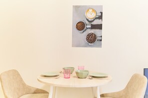 A round table with plates, bowls, and a pink glass. - Granduo Shirokane 2 (Minato City)