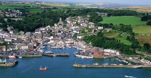A coastal town with a harbor, boats, and a castle-like structure.