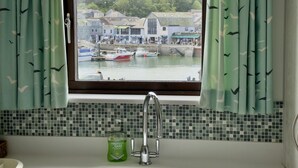 Un baño con vista al puerto, un lavabo y una botella de jabón para manos.