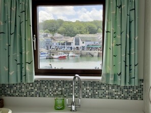 A bathroom with a window view of a harbor, a sink, and a bottle of hand soap. - 2 Red Brick Building - central Padstow with beautiful estuary  & harbour views (Padstow)