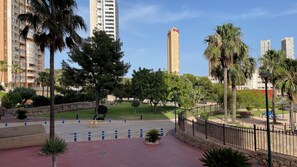 A residential area with high-rise buildings, a well-maintained lawn, and a paved walkway.
