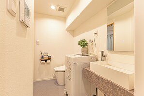 Een haardroger, handdoeken, zeep, toiletpapier