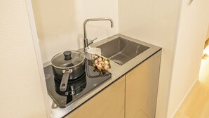 Eine kleine Küche mit Herd, Spüle und Arbeitsfläche.