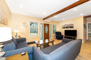 A living room with a sofa, a coffee table, a TV, and a fireplace. - Hungry Horse Hideout - Lower Level (Hungry Horse)