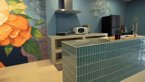 A bathroom with a tiled vanity, a microwave, and a sink with a gold faucet. - Maison Chinoise Midnight Muse: Chinatown & Songwat 4Bed 3Bath (Krung Thep Maha Nakhon)