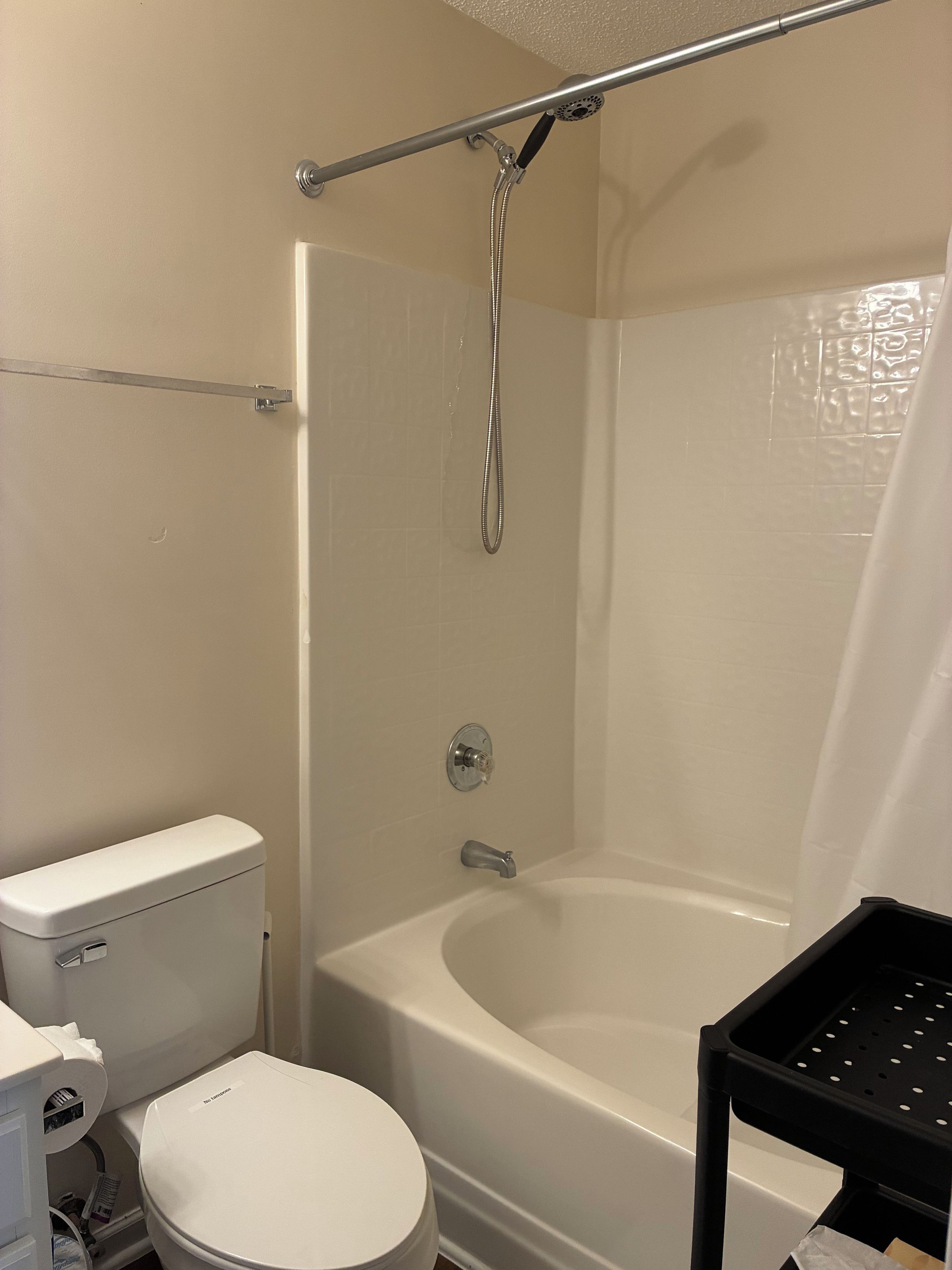 A bathroom with a toilet, a bathtub, and a shower.