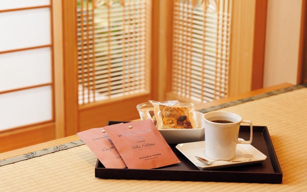 A tray with a cup of coffee, a bowl of food, and a menu on a tatami mat.