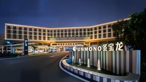 A modern hotel with a curved facade, illuminated signage, and a landscaped entrance area. - Shengbaolong International Hotel (Wuhan)