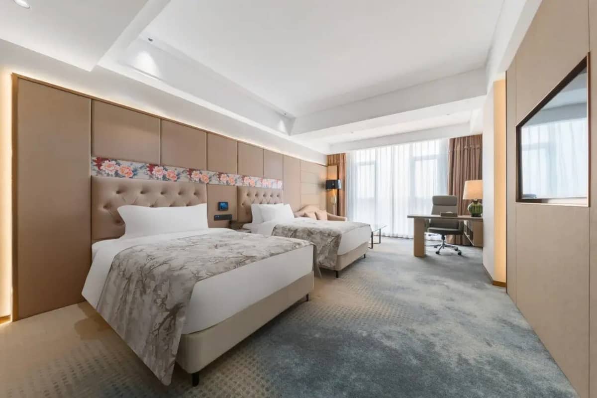 Una habitación de hotel con dos camas, un escritorio y una silla.