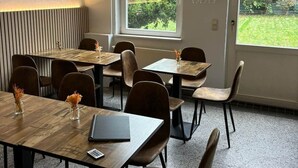 A dining area with tables, chairs, and a view of greenery outside. - Villa Jade - Earthgarden (Jade)