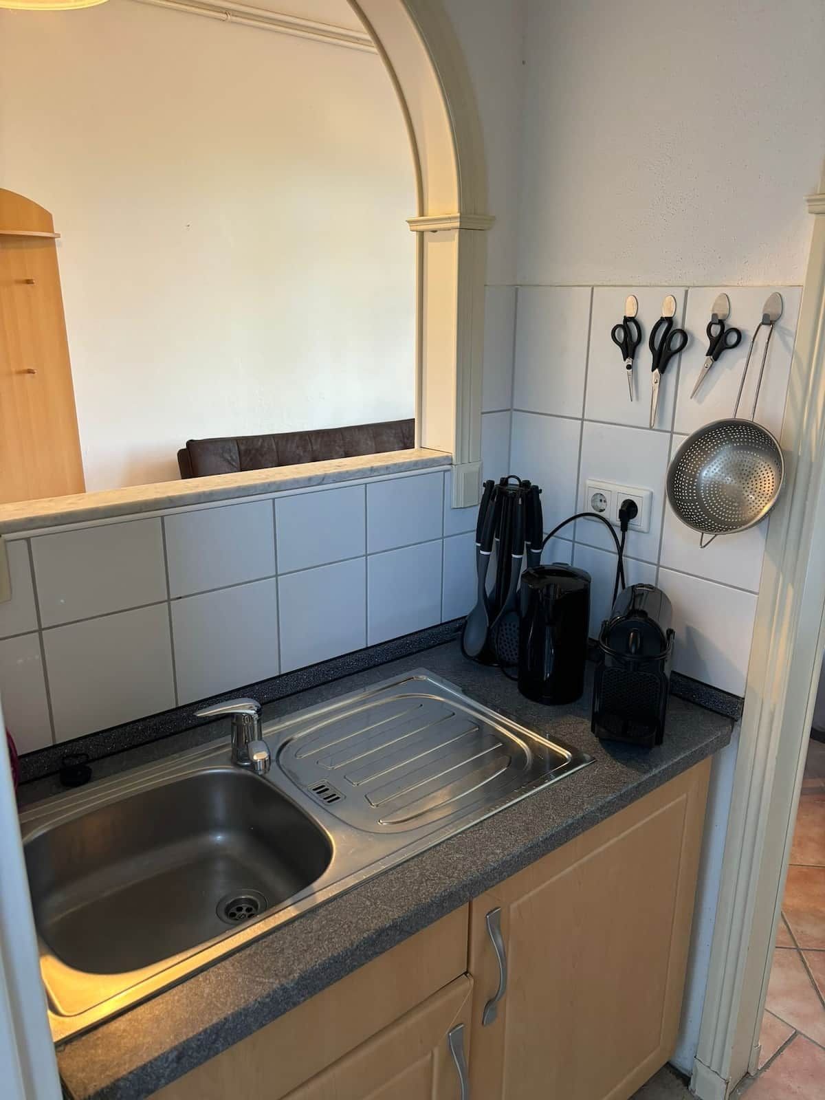 Eine Küche mit Spüle, Arbeitsplatte und verschiedenen Küchenutensilien.