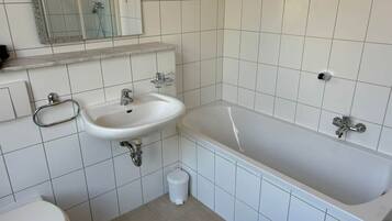 Ein Badezimmer mit Waschbecken, Toilette und Badewanne.