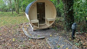 A wooden structure with a curved roof, a door labeled 'HOME DELUXE,' and a small porch area.