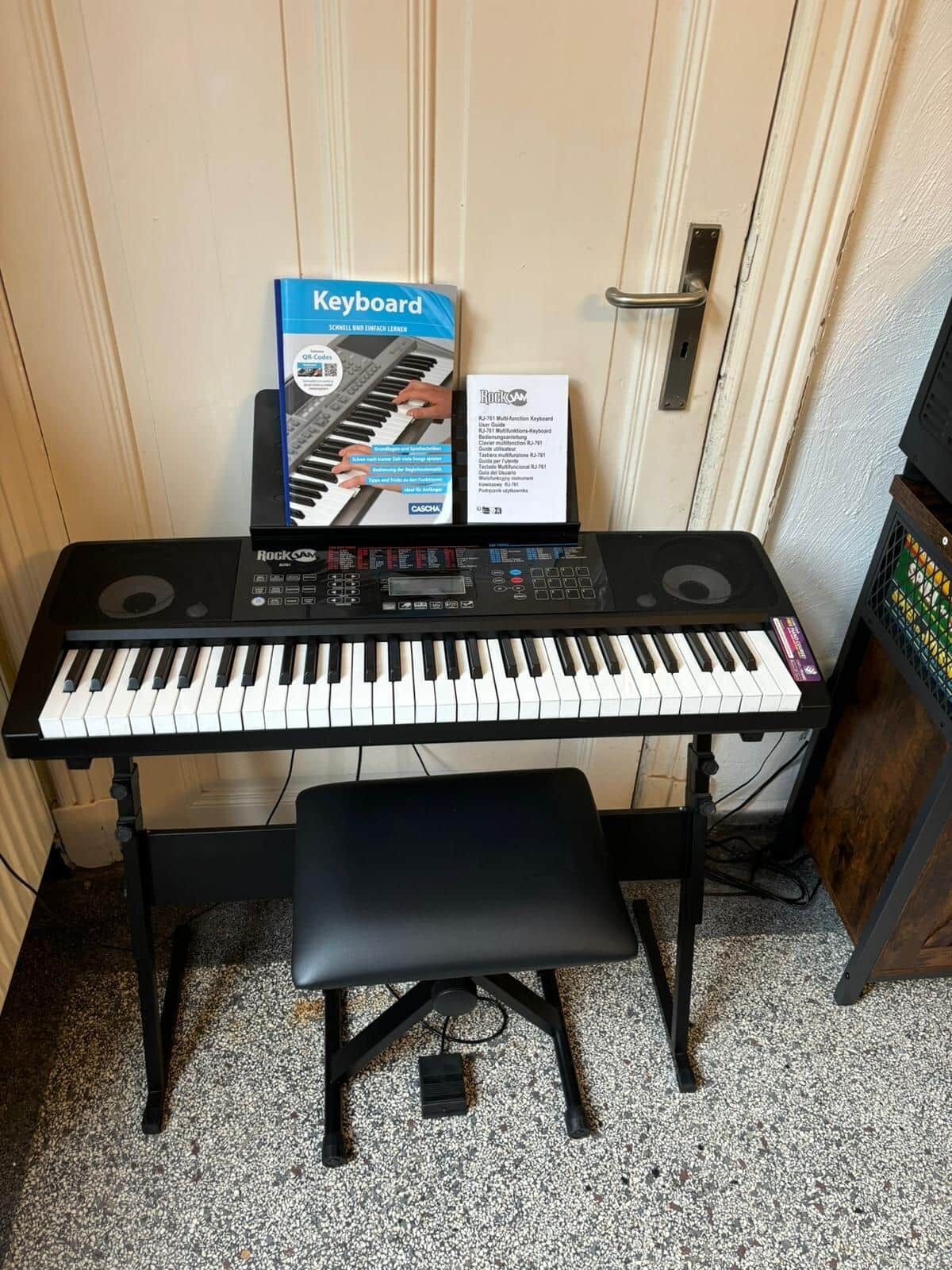 Un clavier avec un support, un banc et une boîte avec du texte.
