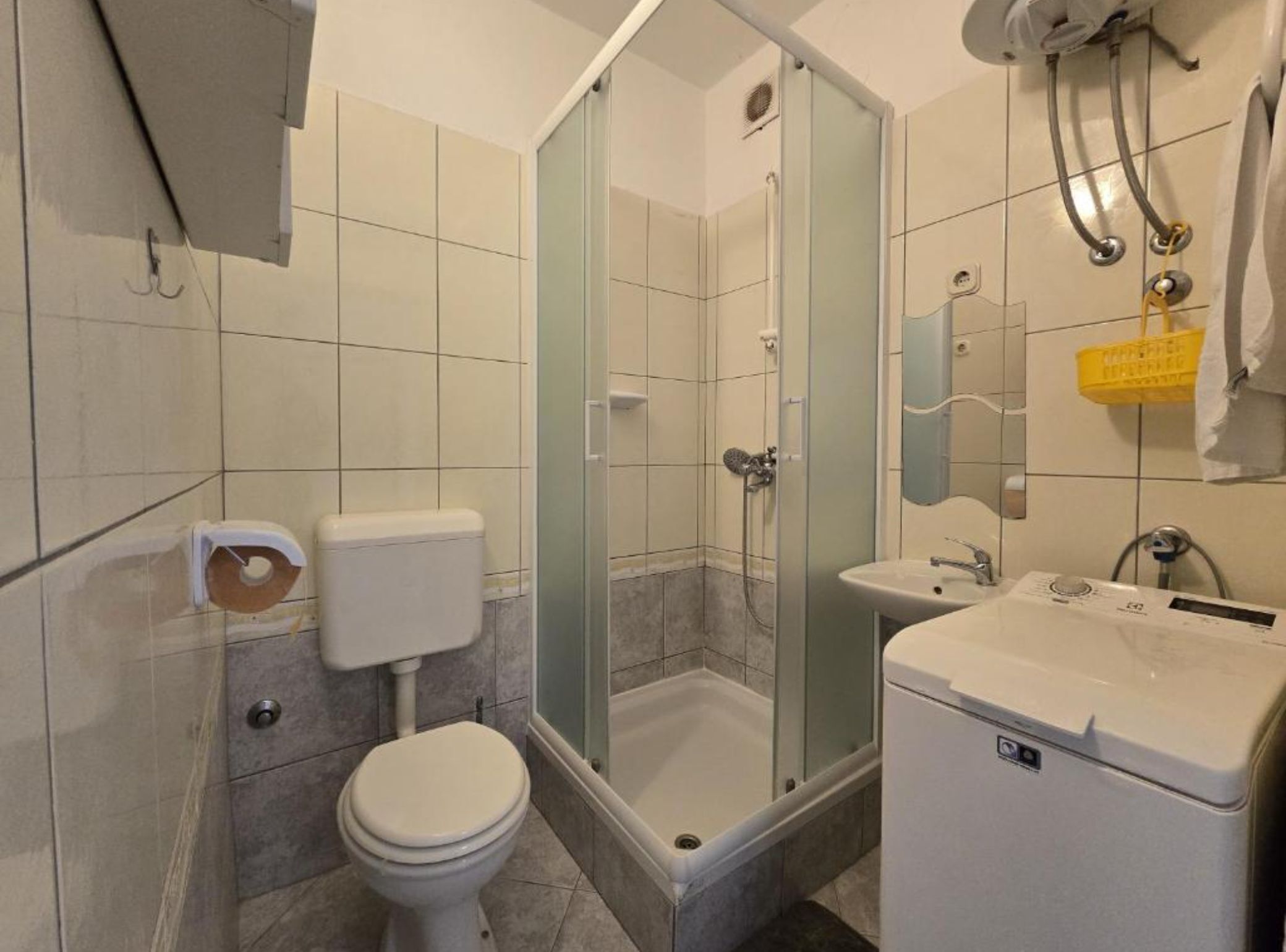 Un bagno con un WC, uno spazio doccia e un lavandino.