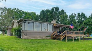 A house with a deck, a staircase, and an American flag. - Game Room, Fishing Cabin & Dock on Grand Lake! (Grove)
