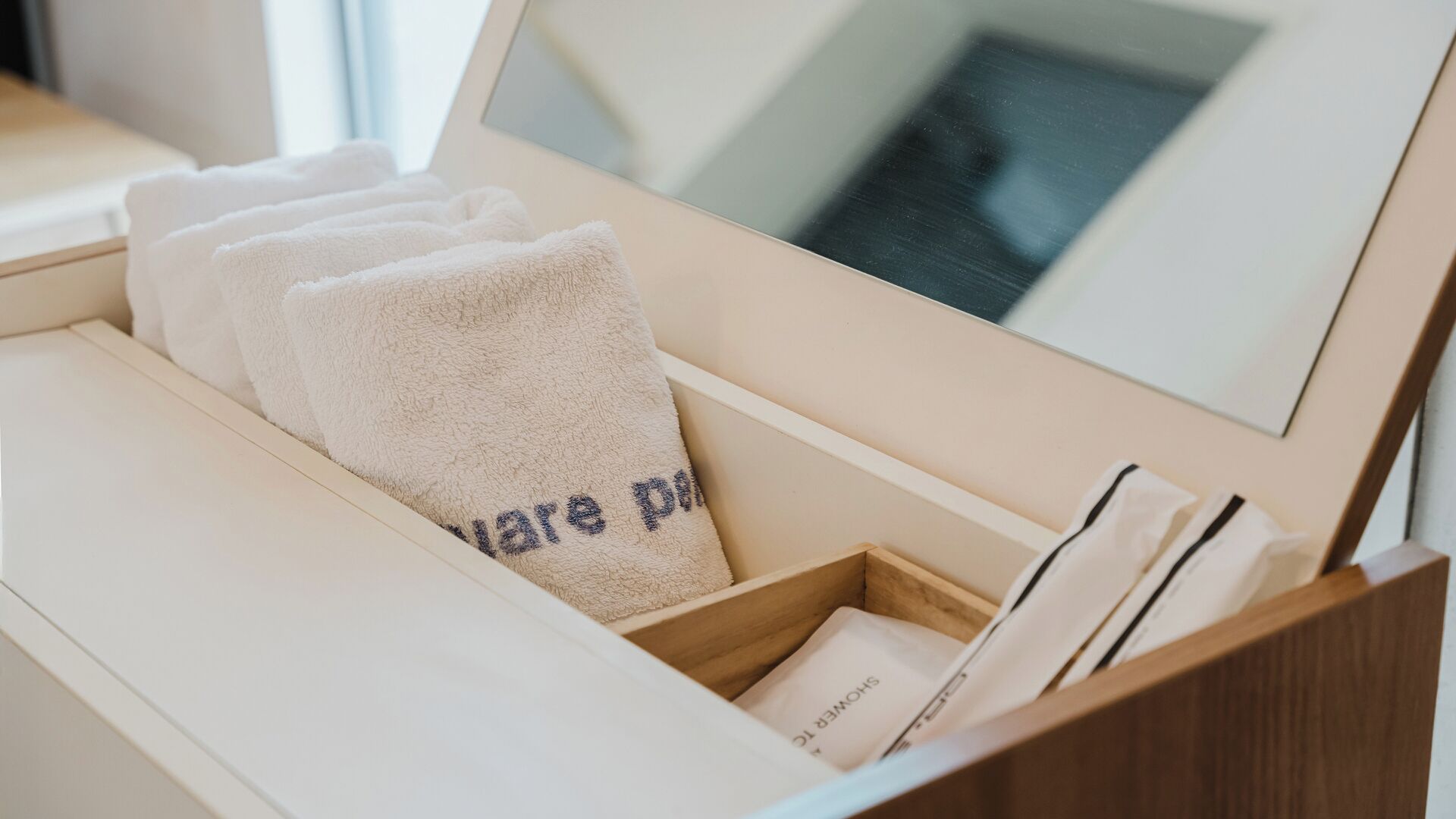 A drawer with towels and a framed picture.
