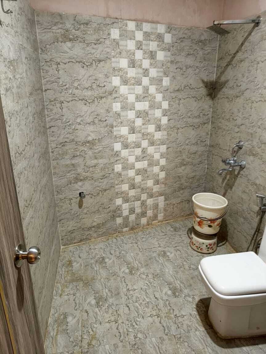 A bathroom with a shower, a toilet, and a sink.