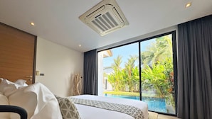 A bedroom with a large bed, a ceiling air conditioner, a view of a swimming pool, and a sliding glass door. - Blue Coral Luxury Villa  (Tambon Sa Khu)