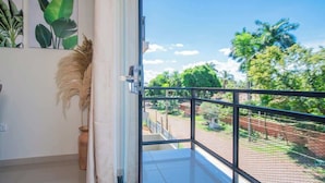 A balcony with a view of greenery and a tiled floor. - Corporate Stays Insignia Fly (Luque)