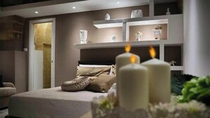 Ein Schlafzimmer mit einem Bett, einem Nachttisch, einem Regal mit Dekoration und einer Tür.