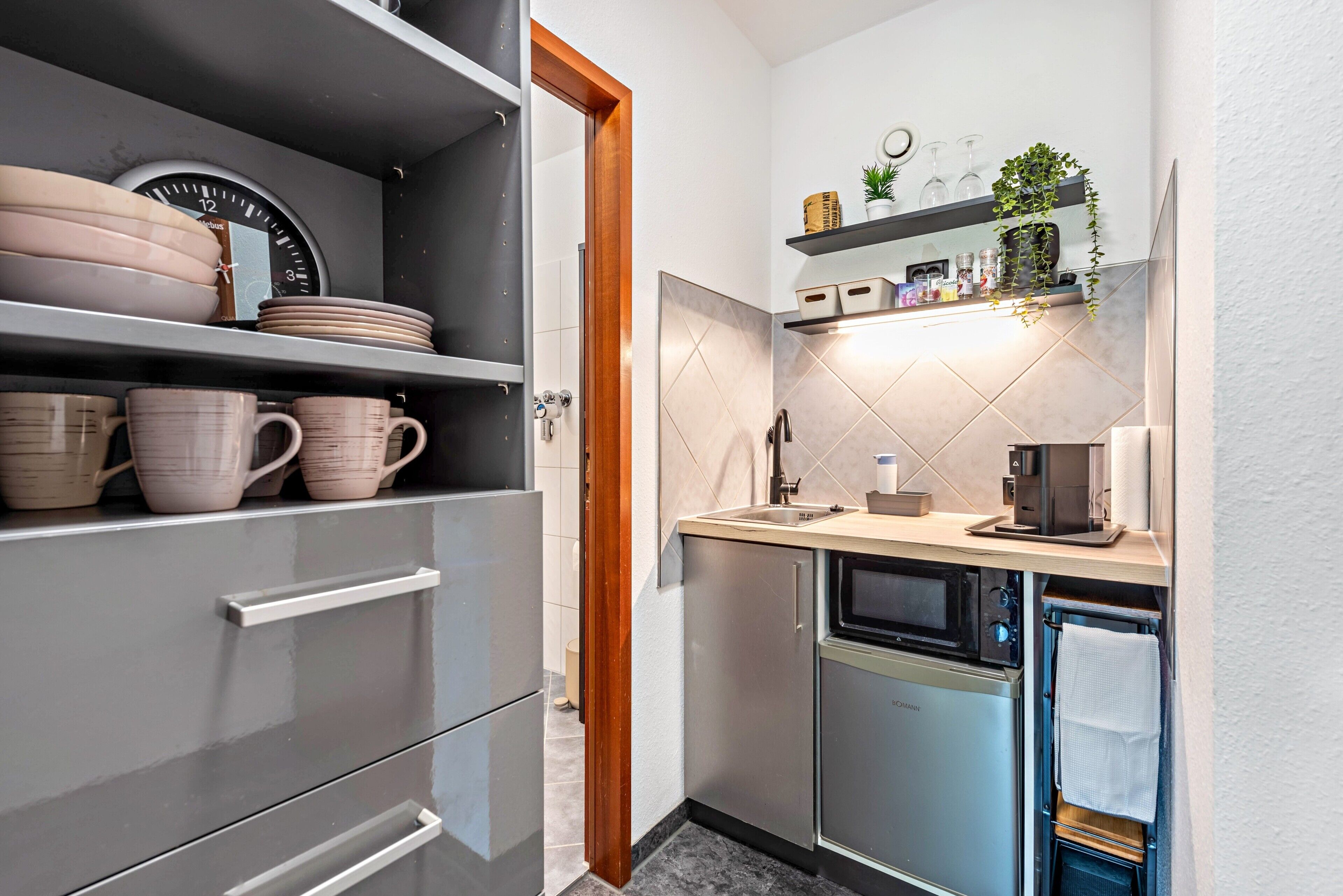 Eine kleine Küche mit Backofen, Kaffeemaschine und Spüle.