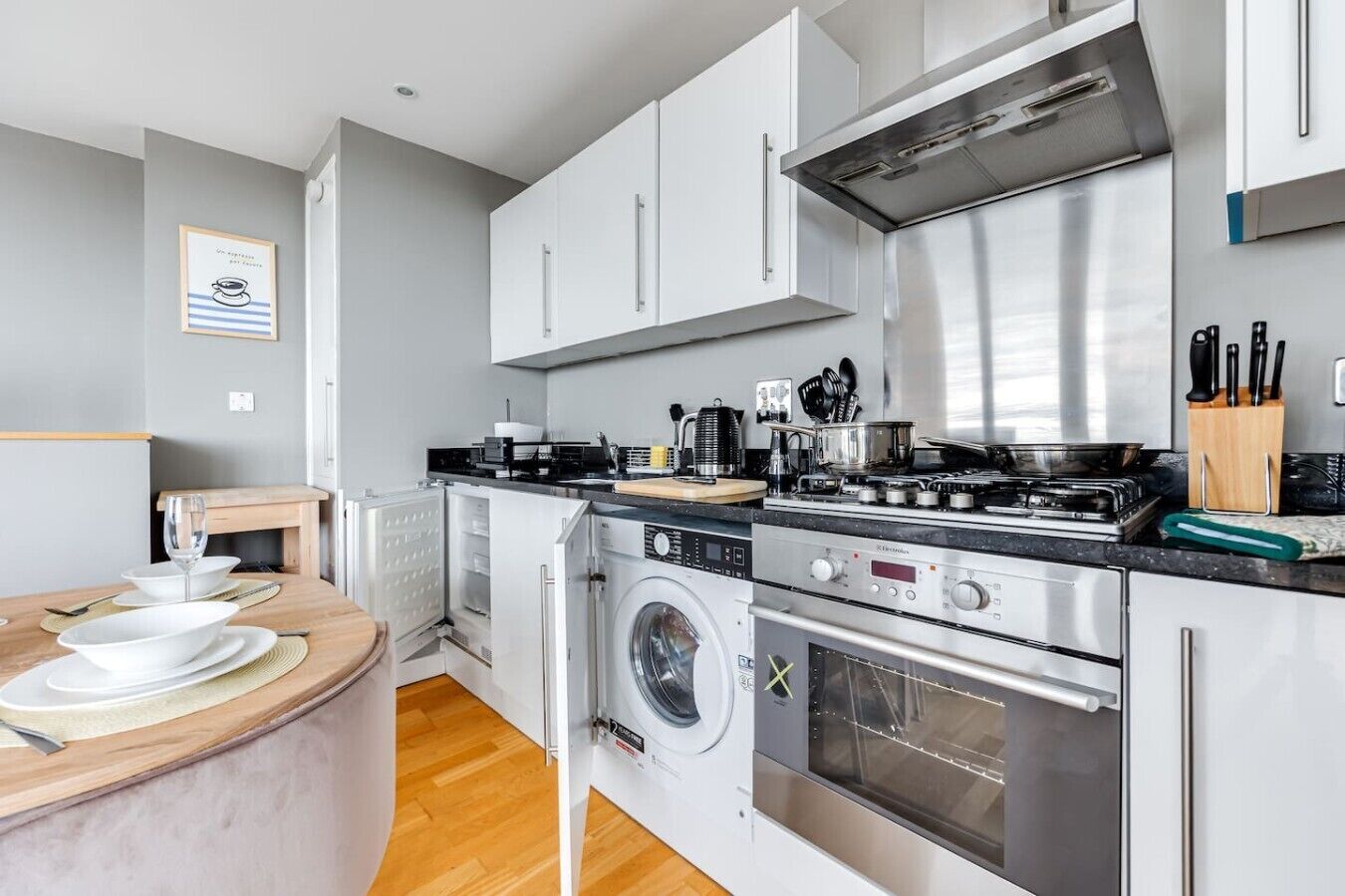 A compact kitchen with a built-in washer, a stove, and a microwave.