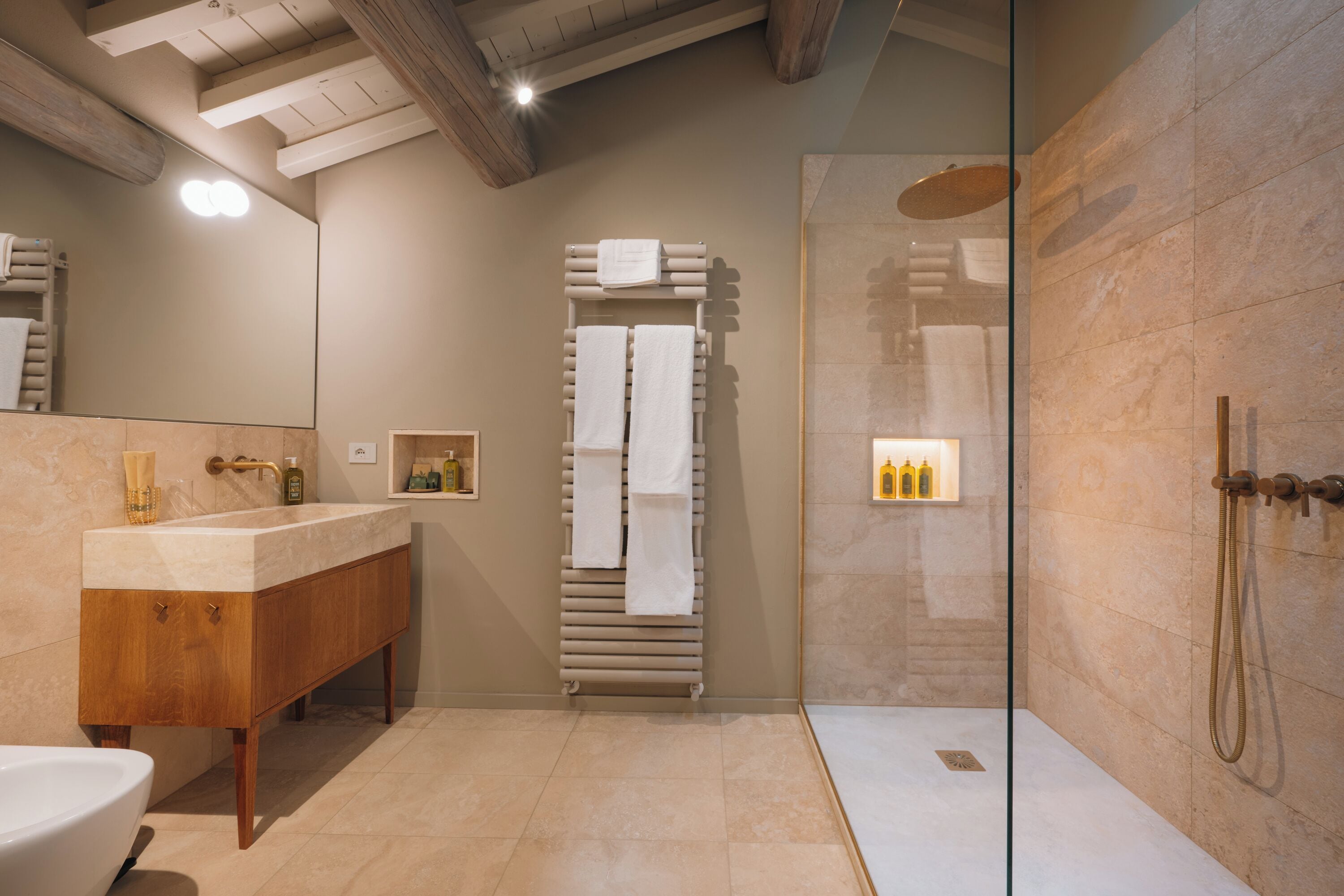 Ein modernes Badezimmer mit einem Holzkosmetikschrank, einer Duschkabine aus Glas und einem integrierten Handtuchhalter.
