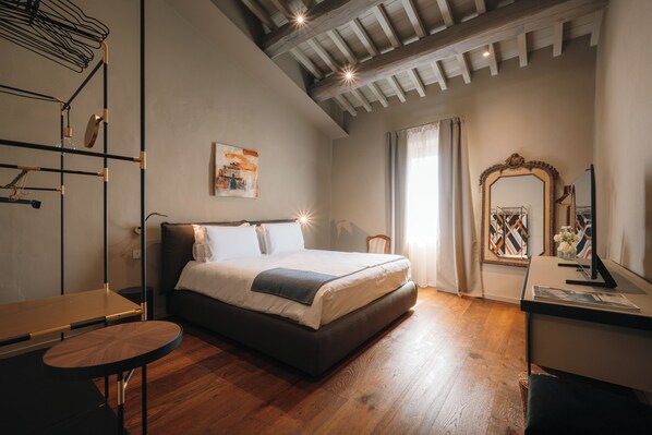 Un dormitorio moderno con una cama grande, un escritorio y un espejo.