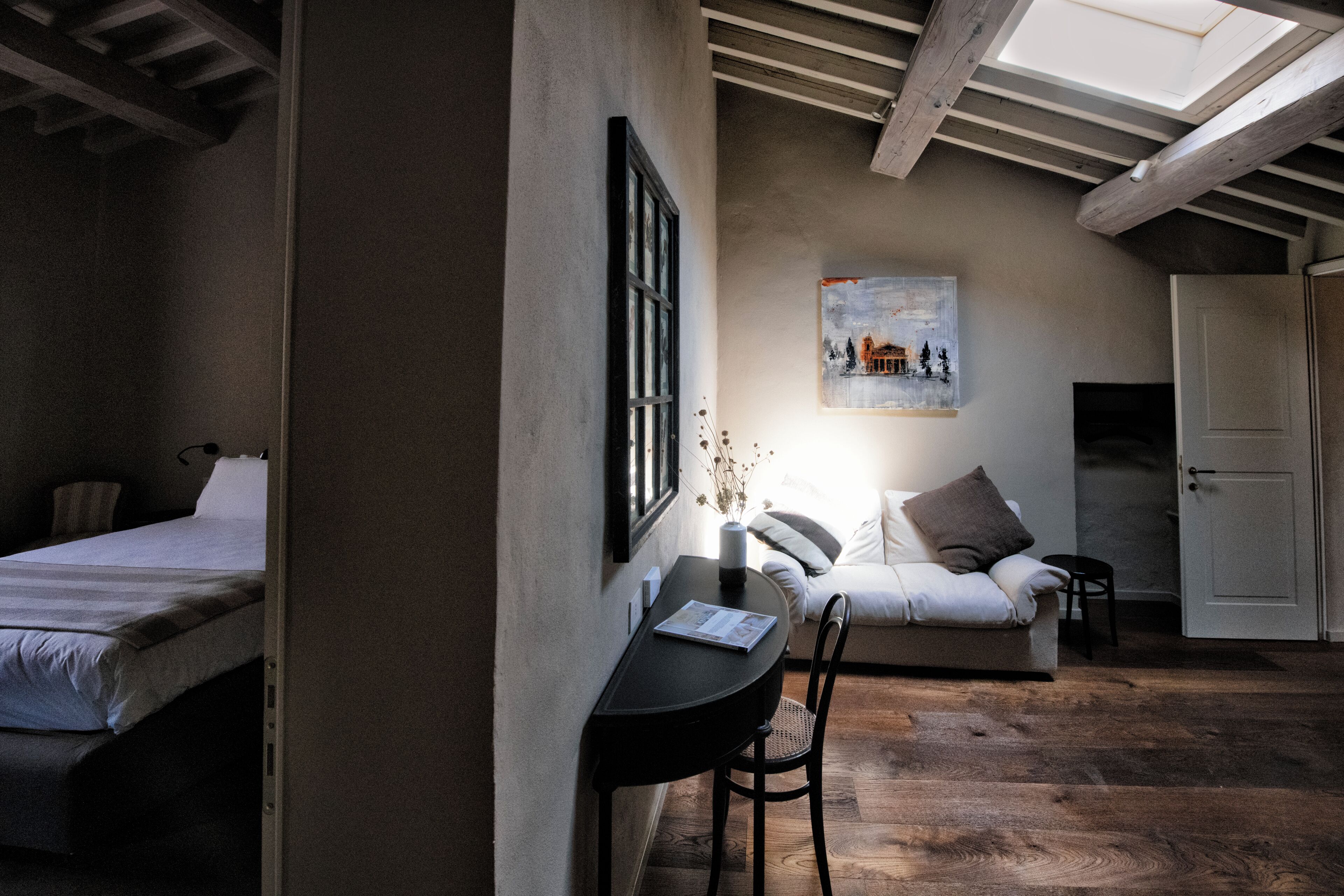 Une pièce comprenant un lit, un bureau avec une chaise, un canapé et une porte.