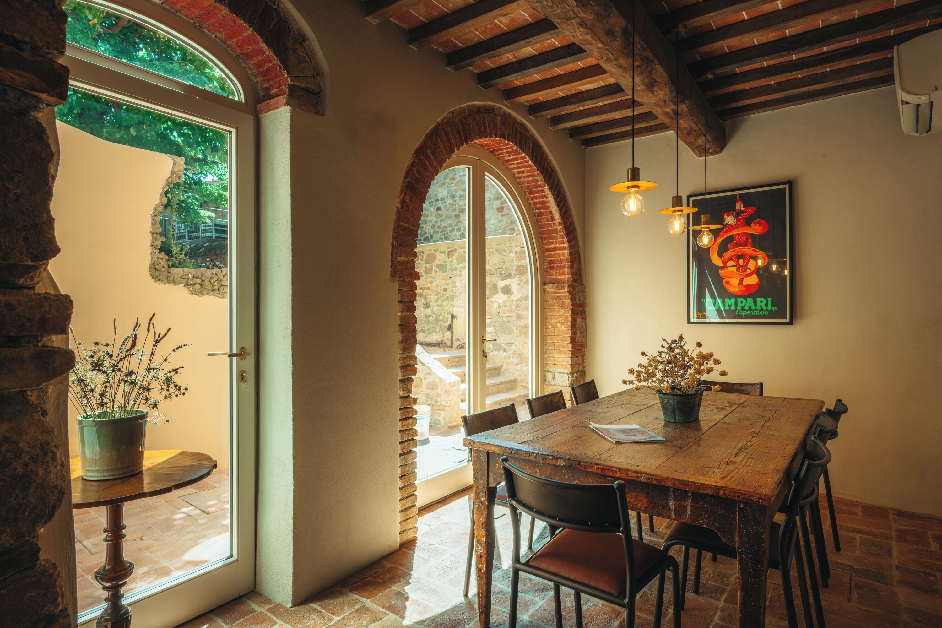 Un coin repas rustique avec une table en bois, des chaises et une plante en pot.