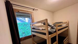 A small room with two bunk beds, a window with a view of greenery, and a curtain. - Family duplex apartment T4 Les Coches / Paradiski / swimming pool (La Plagne Tarentaise)