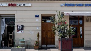 Un edificio con un letrero que dice 'ANKA FOLK SHOTBAR' y otro letrero que dice 'Pijalnia wodki i piwa'.