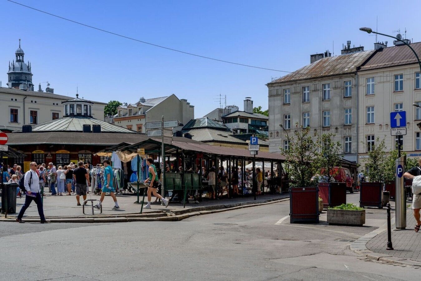 Una animada escena callejera con puestos de mercado, peatones y edificios históricos.