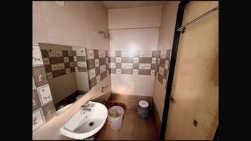 A compact bathroom with a sink, mirror, and tiled walls.
