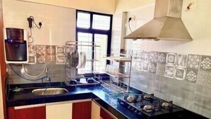 A kitchen with a gas stove, sink, and a window.