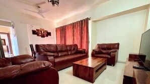 A living room with a sofa set, a coffee table, and a television.