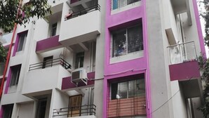A multi-story building with balconies, air conditioning units, and windows.