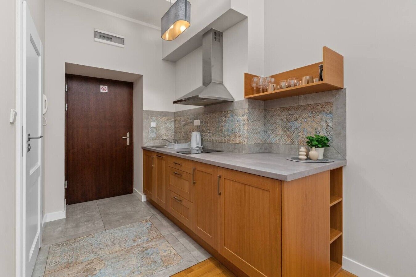 A kitchen with wooden cabinets, a countertop, a built-in oven, and a backsplash.